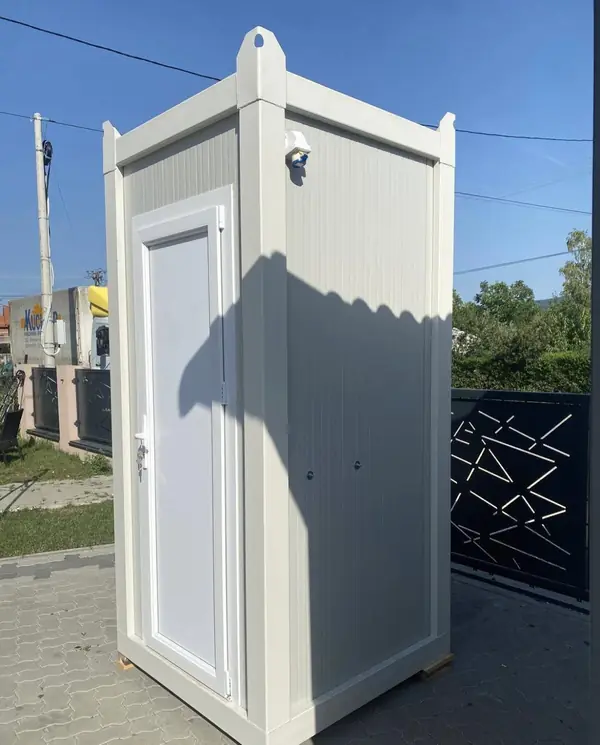 White single flushing restroom cabin on a paved patio