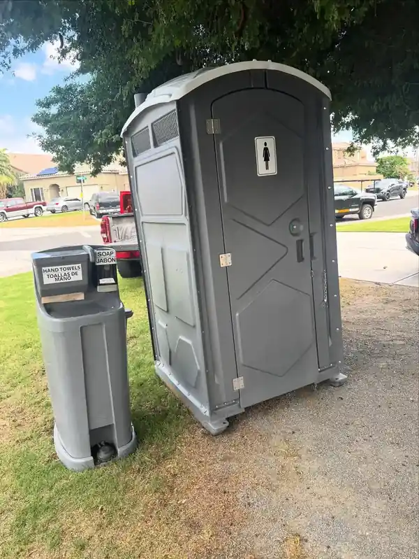 Hand-wash station beside a porta potty