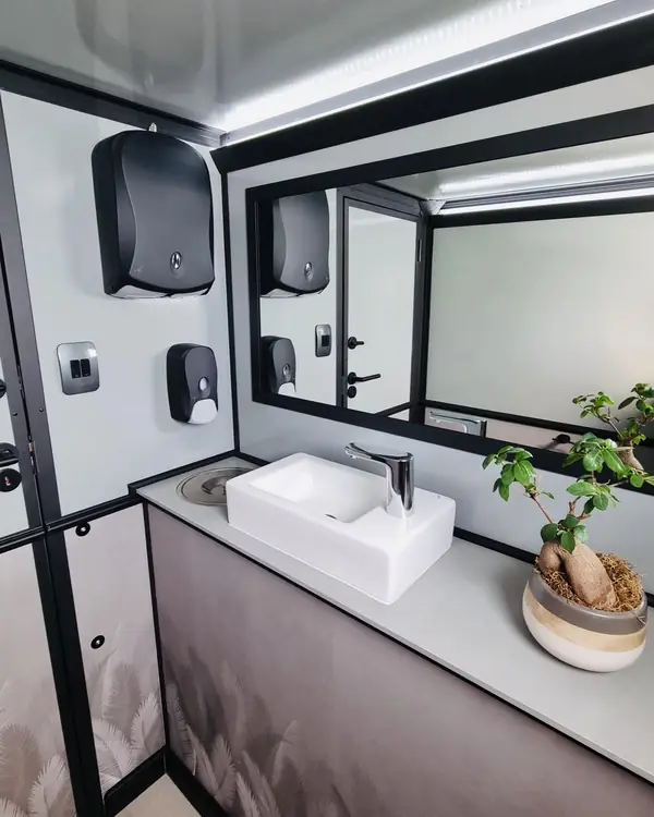 Restroom trailer vanity with sink, soap dispenser and mirror
